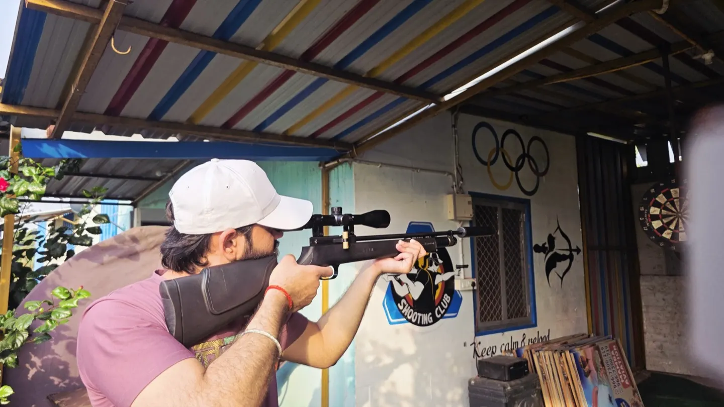 The covered shooting range with a dartboard and archery target
